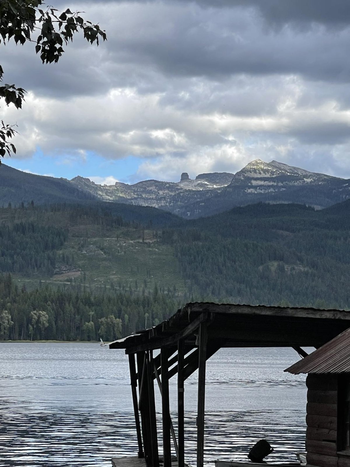 Looking past the historic gas house and dock, out over the lake to Chimney Rock rising from the mountains.