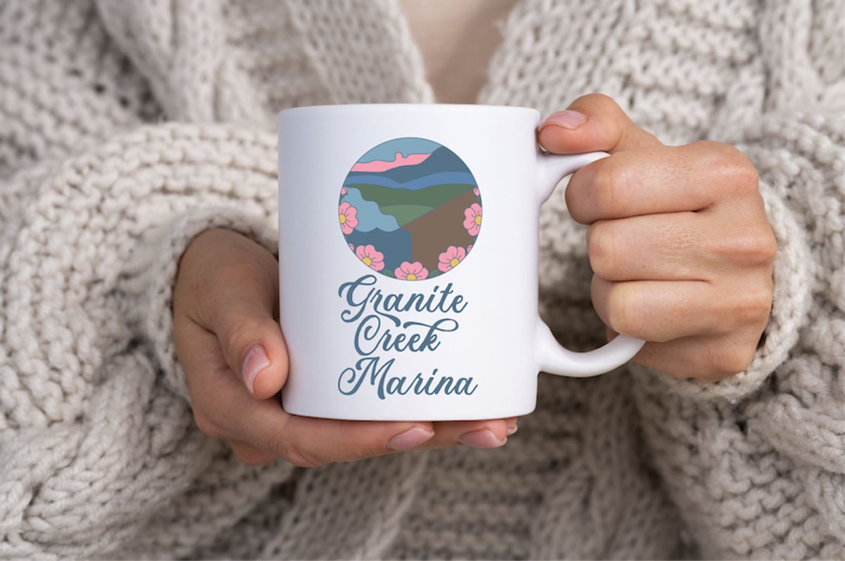 The primary logo vertical on a mug held by someone wearing a cozy sweater.